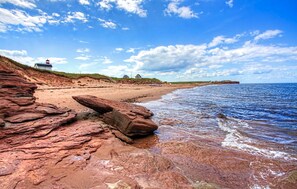 Ranta lähistöllä, aurinkotuoleja, rantapyyhkeitä