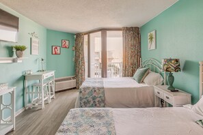 Un dormitorio con dos camas, un escritorio, una silla y una ventana con cortinas.