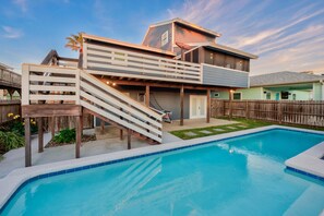 Une maison moderne dotée d’une piscine, d’une terrasse couverte et d’un garage.