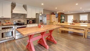 Una cocina amplia con electrodomésticos modernos, una gran mesa de madera y una zona de estar acogedora.