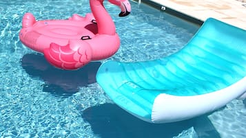 Enjoy a refreshing swim in the pool, which features a fun inflatable slide and a floating flamingo.