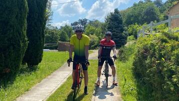 Dos ciclistas en un sendero estrecho rodeado de vegetación.