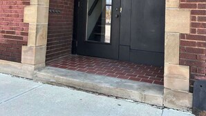 A black door with a 'DOYLE' sign above it, set in a brick building. - Hotel Quality/ Walkable / Free Parking/ 3bd #4 (Lakewood)