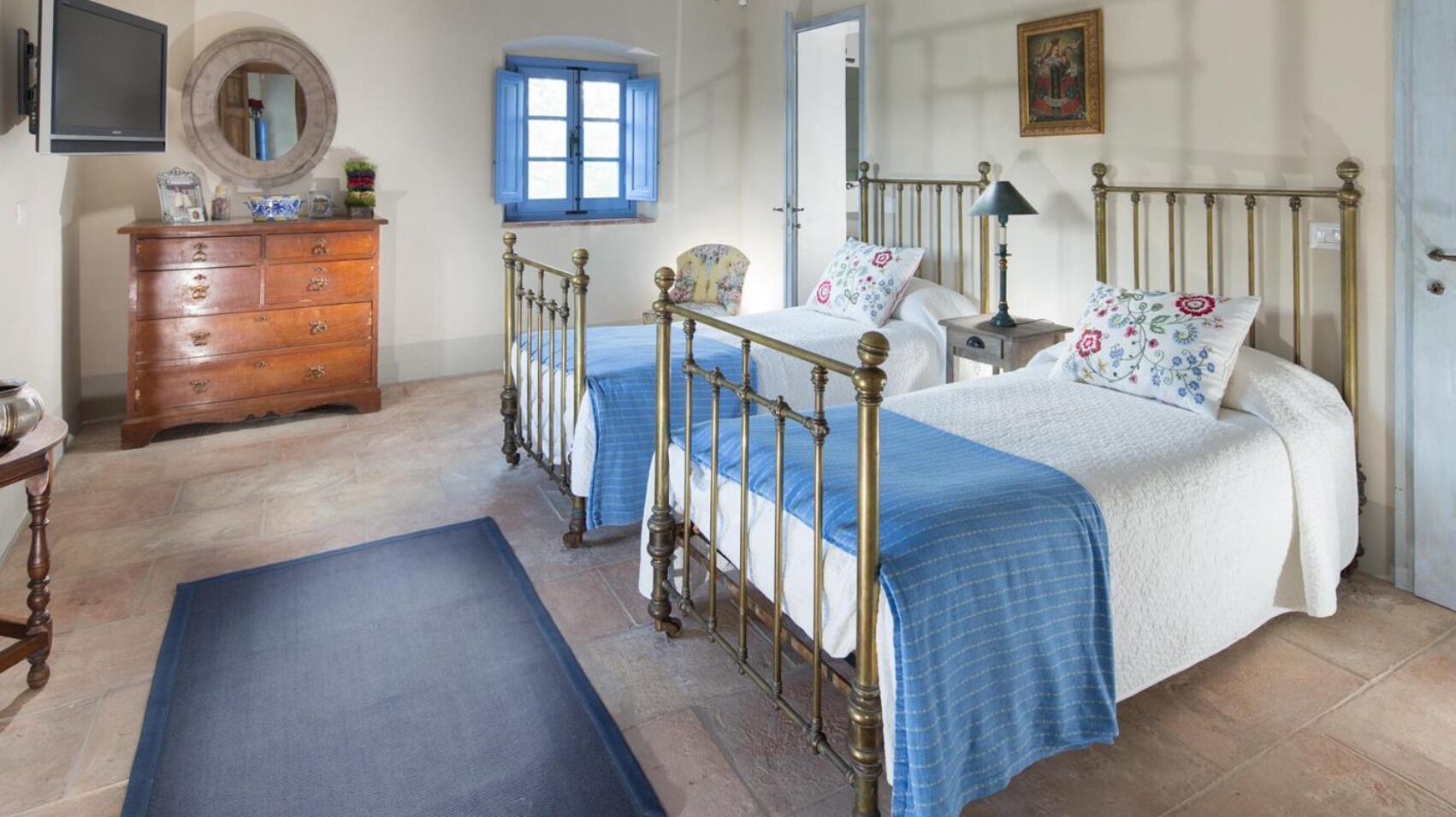 A bedroom with a bed, dresser, and a mirror.