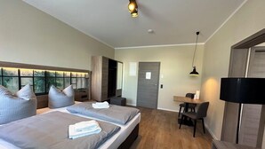 Una camera d'albergo moderna con un letto grande, comodini, una scrivania e una sedia.