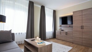 Een moderne woonkamer met een bank, een salontafel, een televisie en een kledingkast.
