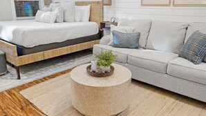 Ein Schlafzimmer mit einem Bett, einer Couch, einem runden Couchtisch und einem Teppich.