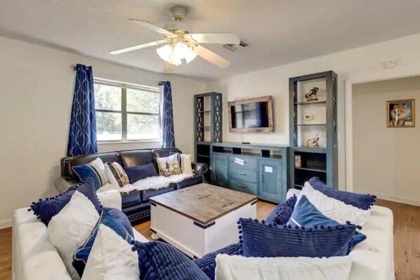 A living room with a sofa, coffee table, and a TV on a cabinet.