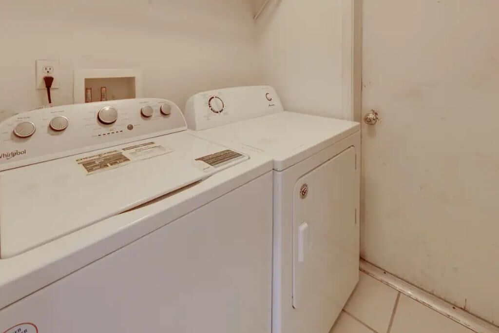 Una lavadora y secadora compacta, de color blanco, con un panel de control que incluye varios diales y botones.