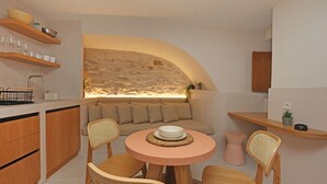 Een moderne keuken met houten kasten, een ronde tafel met stoelen, een ingebouwde bank en een accentmuur van steen.