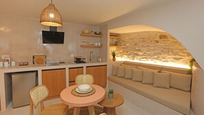 Een moderne keuken met een eethoek, een ingebouwde televisie en een accentmuur van steen.
