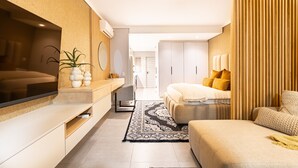 A modern bedroom with a large bed, bedside tables, a TV, and a wardrobe. - Modern Studio l Ocean Views l Steam Room (Cape Town)