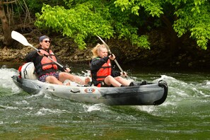 Two people in a kayak on a river surrounded by greenery. - Prehistoric Lodge (Vallon-Pont-d'Arc)