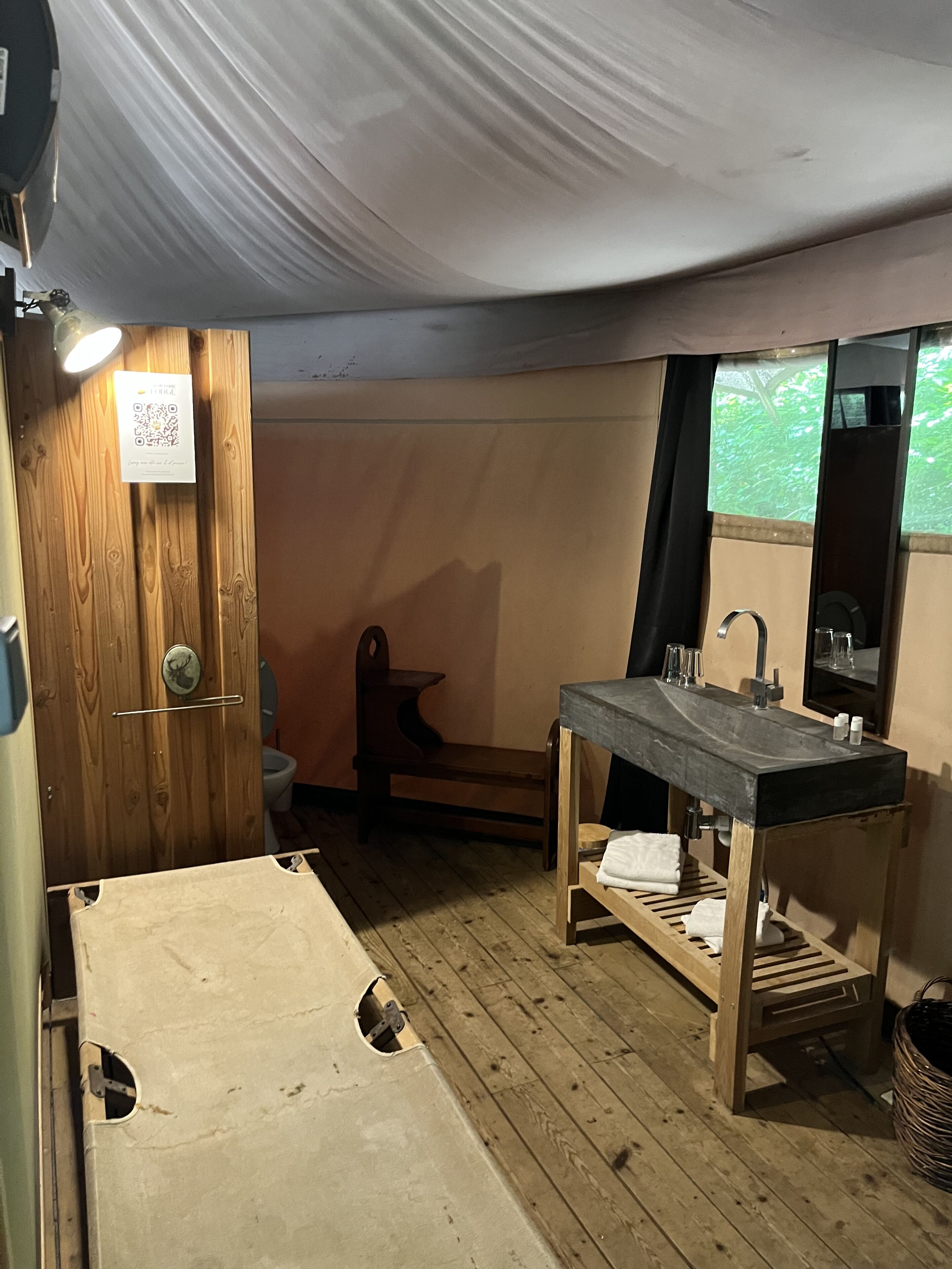 Ein kleines Badezimmer mit Holzboden, Waschbecken mit Spiegel und Toilette.
