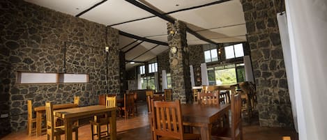 A spacious dining area with stone walls and wooden furniture.