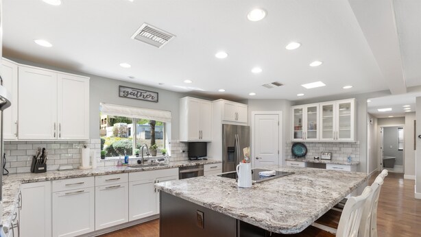 A modern kitchen with white cabinets, a granite countertop, and stainless steel appliances. - Oasis Overlook, Have Fun in Pool/Hot Tub/Putt Grn (Phoenix)