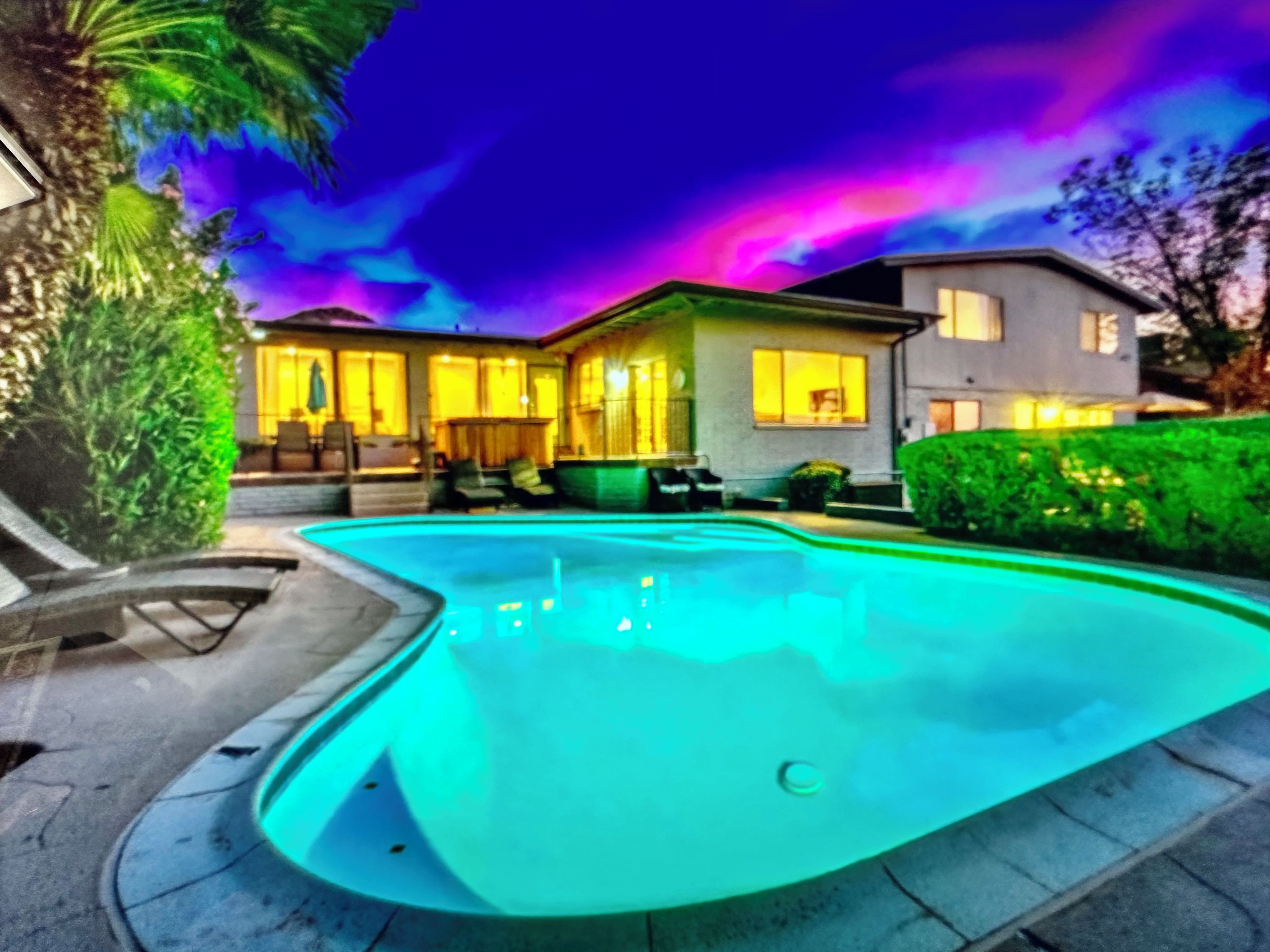 A swimming pool with a house in the background.