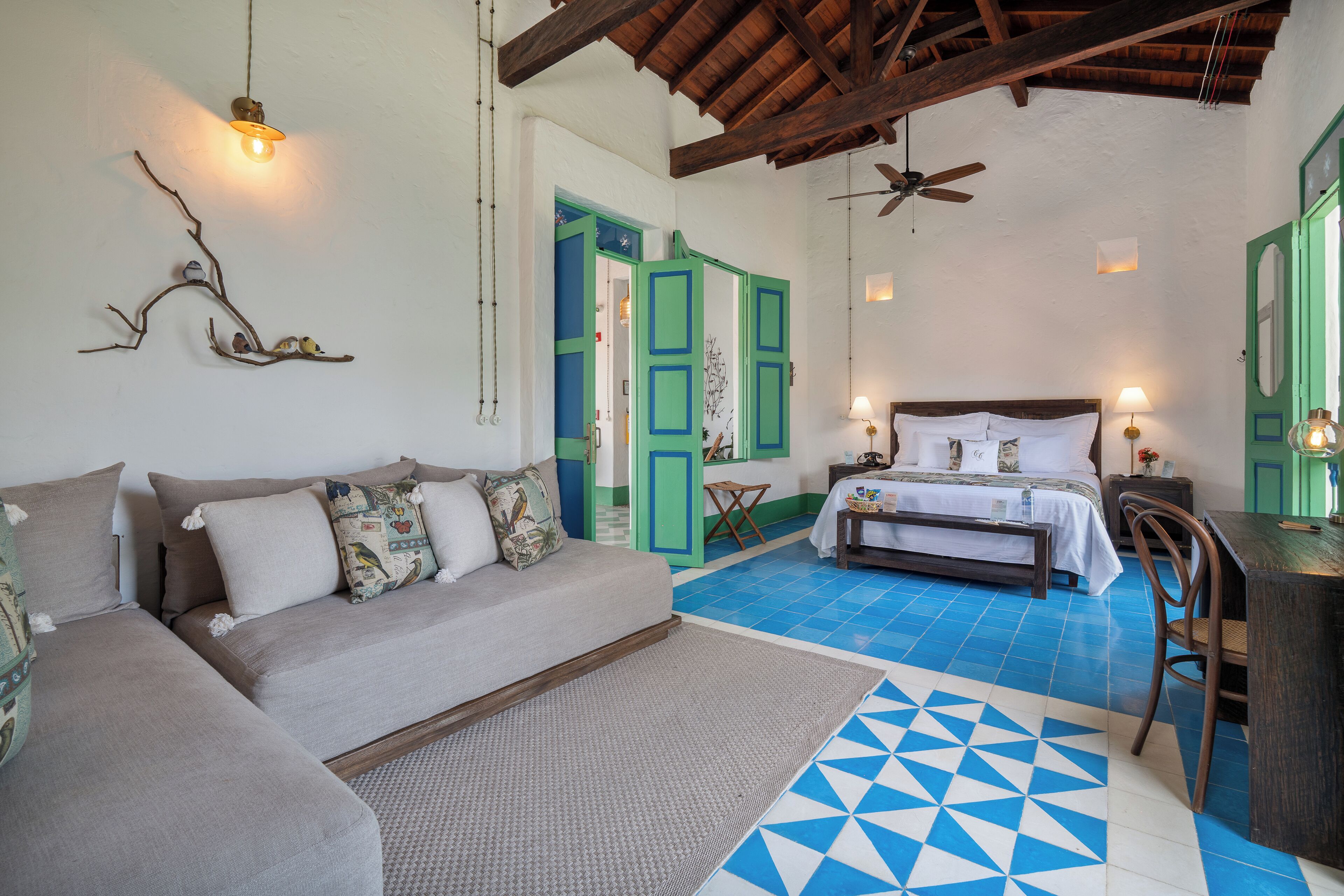 Una habitación con sofá, cama, mesa de comedor y ventilador de techo.