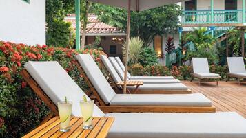 Una piscina al aire libre, sillones reclinables de piscina