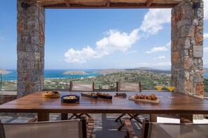 Dine amidst a serene landscape with a scenic view of a body of water and rolling hills.