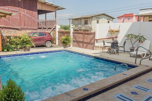 Relax by the pool in an outdoor space with a patio area and comfortable seating.