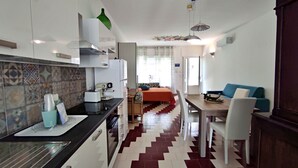 A compact living space with a kitchenette, a dining area, and a bed. - L'Appoggio - Monolocale eco-sostenibile a due passi dal centro storico (Corsano)