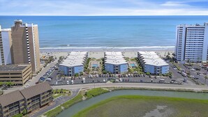 A coastal hotel with multiple buildings, a parking lot, and a view of the ocean. - Oceanview at A Place at the Beach 3 - Unit 3E (Myrtle Beach)