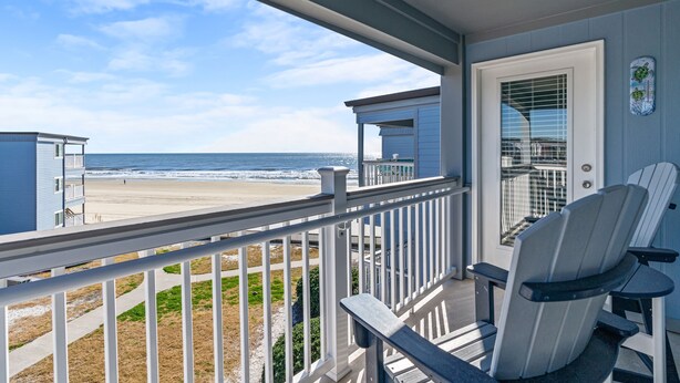 A balcony with a view of the beach and ocean. There are two Adirondack chairs and a small table. - Oceanview at A Place at the Beach 3 - Unit 3E (Myrtle Beach)