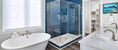A modern bathroom with a freestanding bathtub, a glass-enclosed shower, and a vanity with a sink.