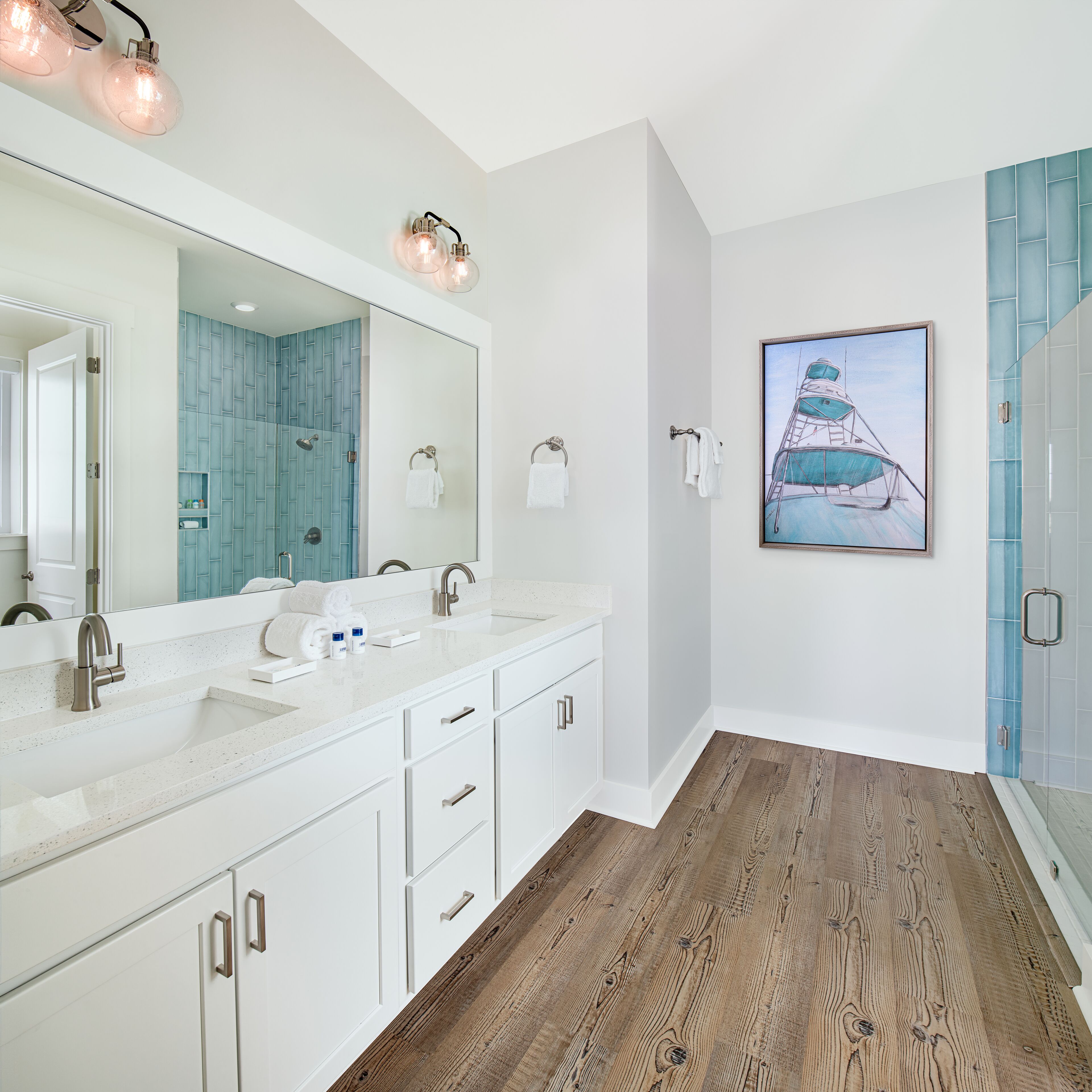 Une salle de bain moderne avec un grand miroir, deux lavabos et un espace douche.