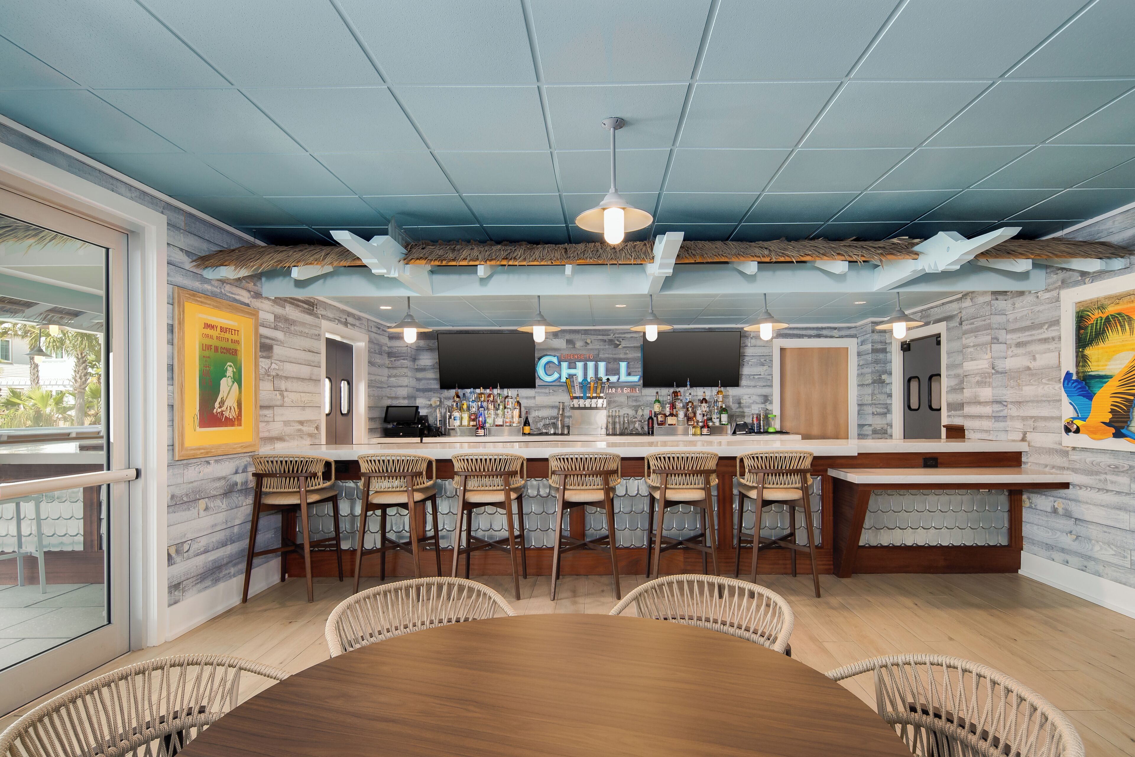 A bar area with a 'CHILL' sign, wooden bar counter, and wicker chairs.