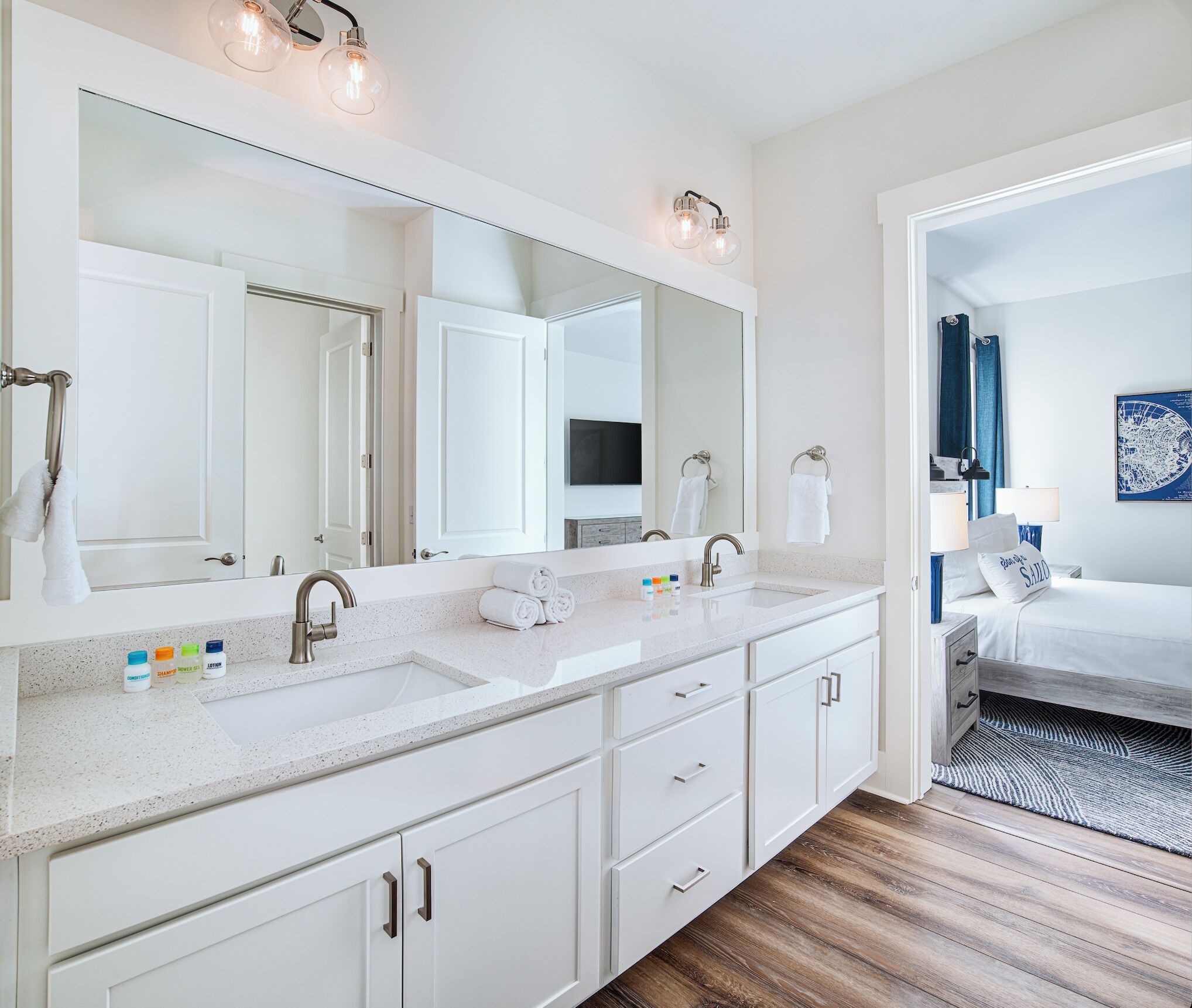Un baño moderno con lavamanos doble, espejo grande y ducha a ras de suelo.