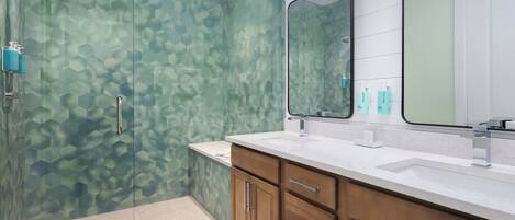 A modern bathroom with a shower, vanity, and cabinets.