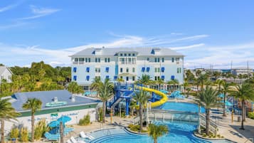 Un complexe hôtelier doté d’une grande piscine, d’un toboggan aquatique et d’un bâtiment comportant de nombreux balcons.