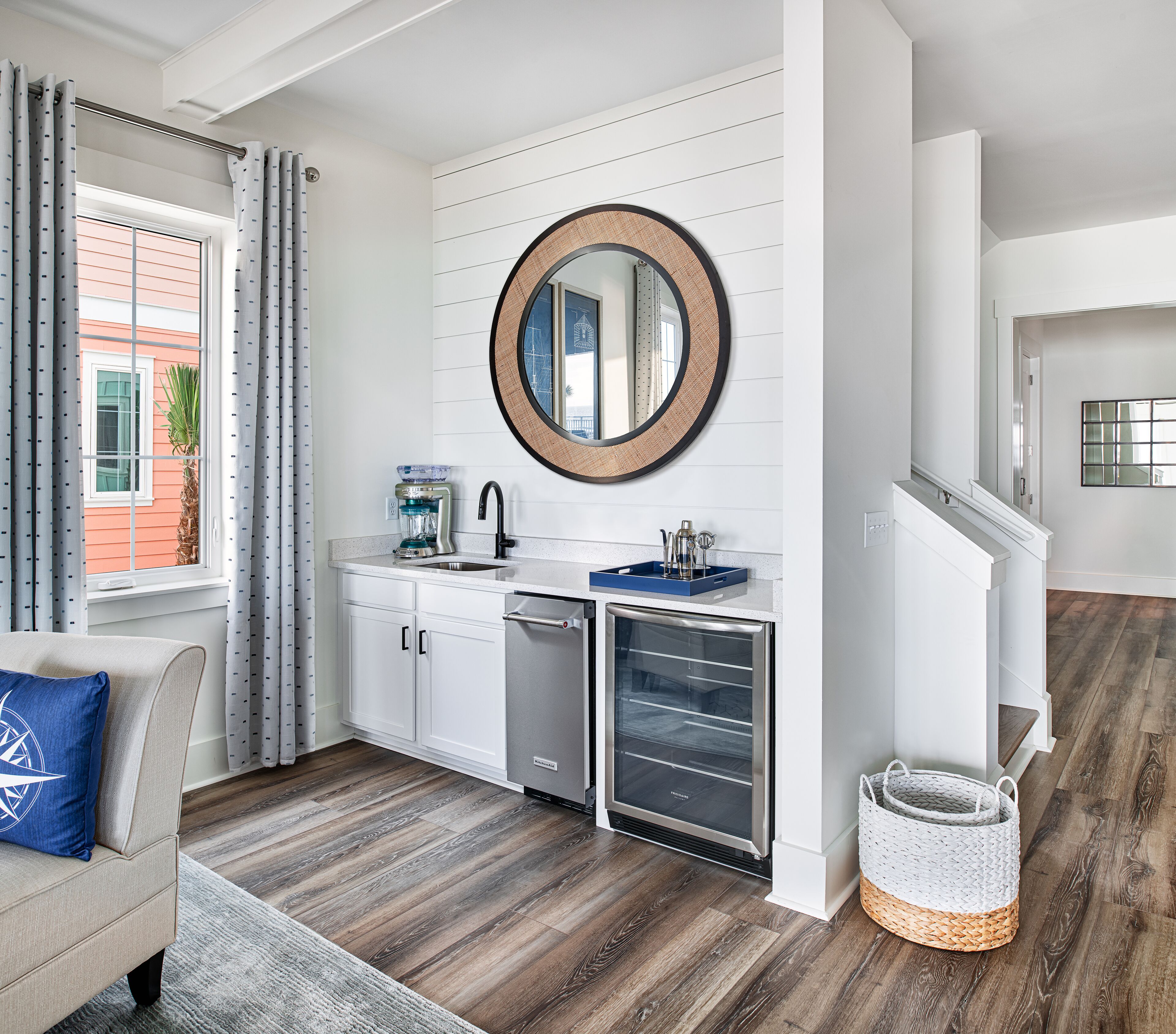 A modern kitchen with white cabinetry, a built-in dishwasher, and a compact refrigerator.