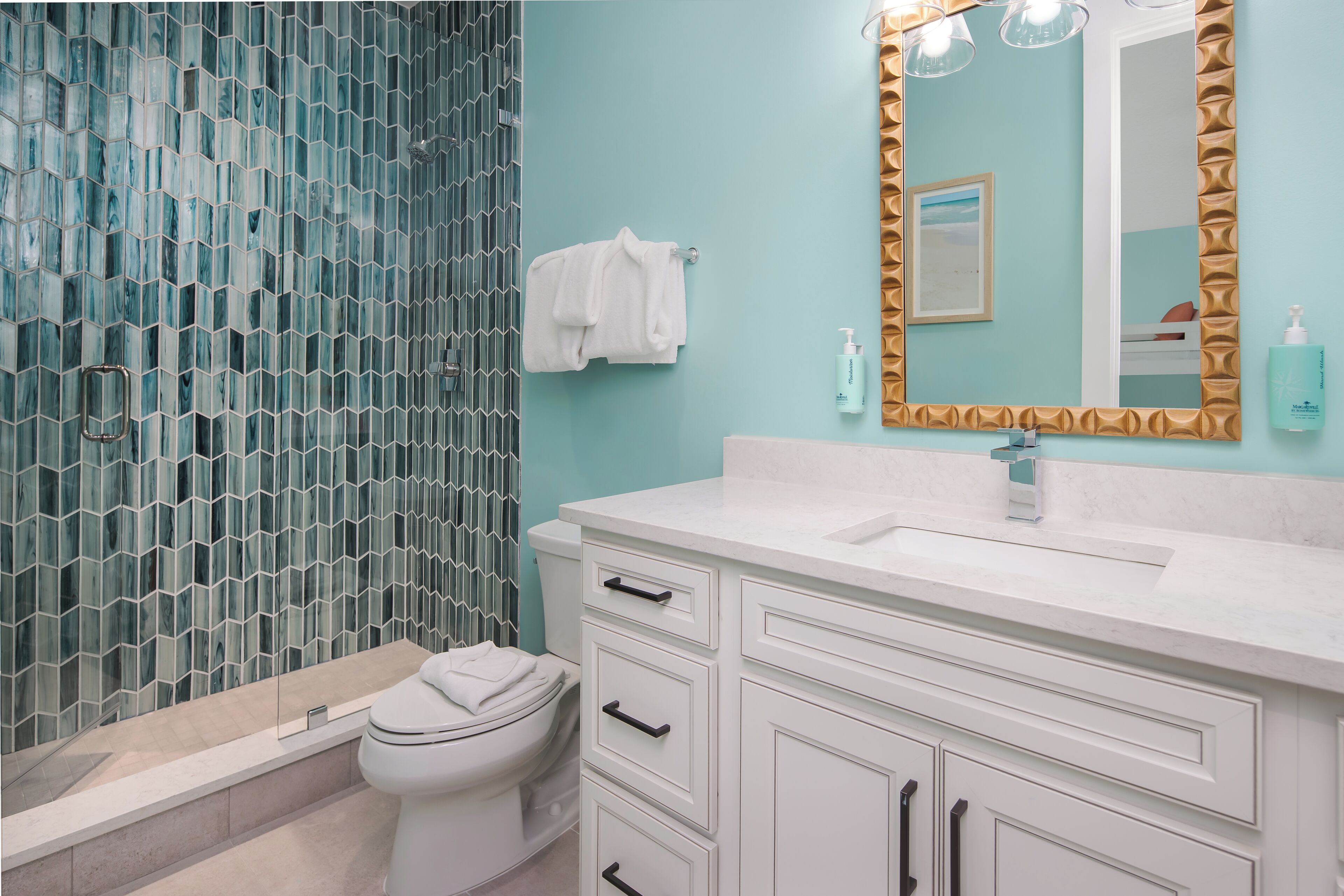 A bathroom with a toilet, a sink, and a mirror.