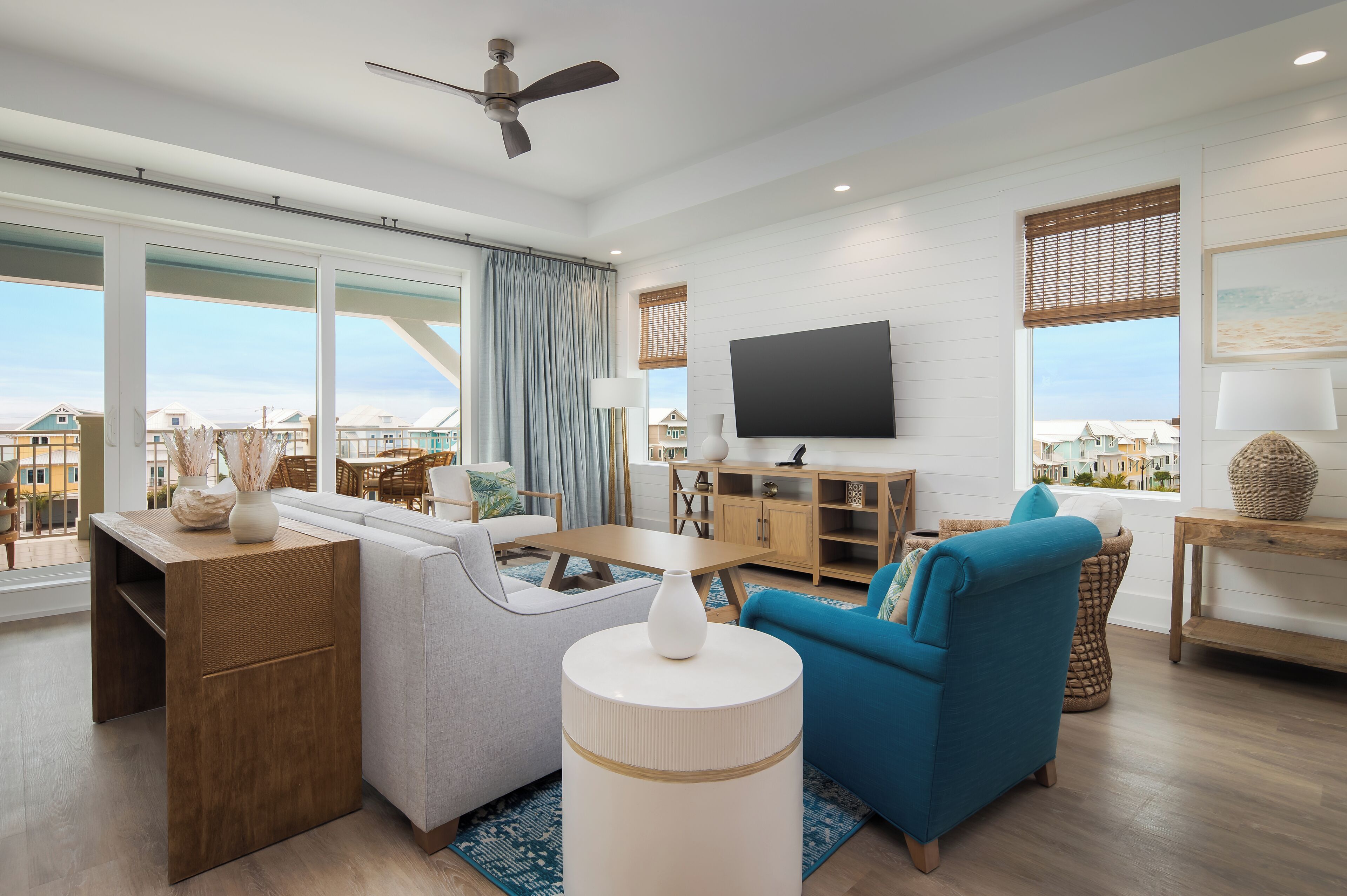 Uma sala de estar moderna com sofá, poltrona, televisão e um espaço de refeições.