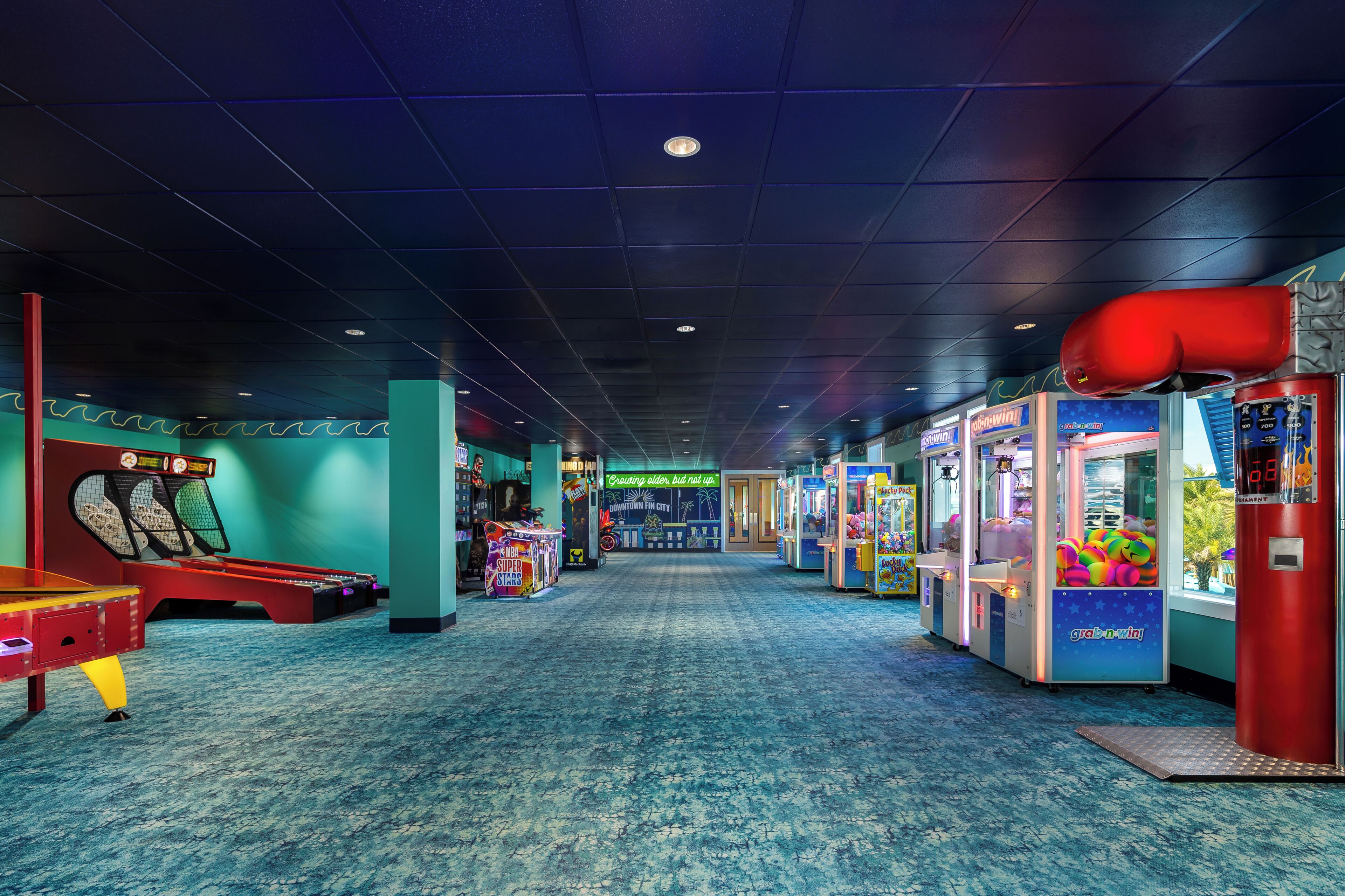 Une salle d’arcade intérieure avec des jeux de griffe et une table de baby-foot.