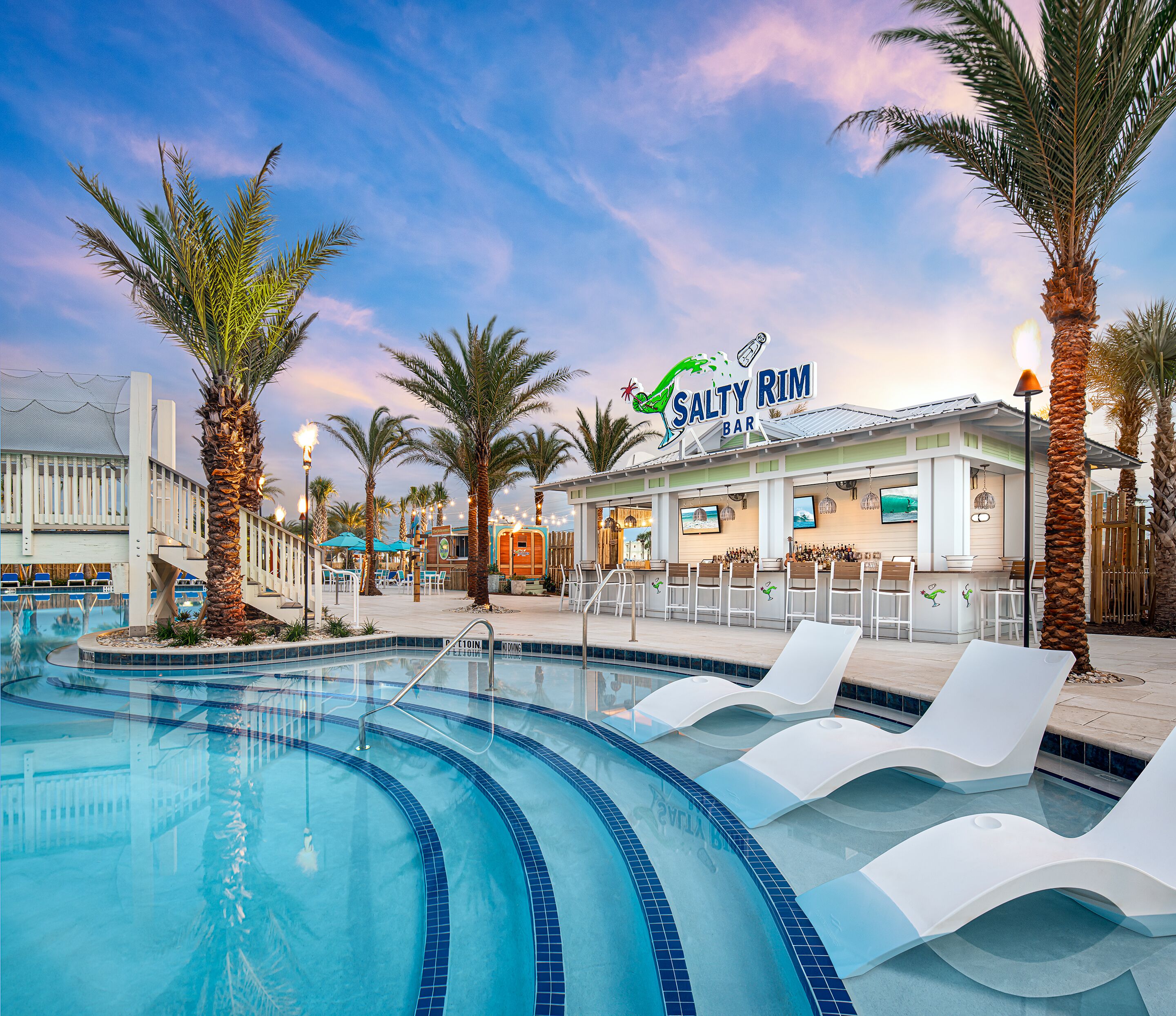 A pool area with lounge chairs, palm trees, and a bar named Salty Rim.