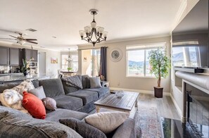 A modern living room with a grey sectional sofa, a coffee table, and a fireplace.