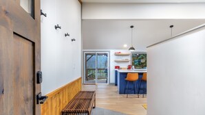 A modern kitchen with a bar area, wooden bench, and a view of the outdoors. - Waterfront Cabin at White Pass, Mt. Rainier (Packwood)
