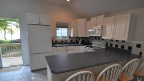 A modern kitchen with white cabinets, a granite countertop, and a built-in oven.