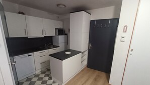 A compact kitchen with white cabinets, a black countertop, and a checkered floor. - Le Corbier - Résidence Les Pistes, Appartement 6/7 Personnes au Pied des Pistes (Villarembert)