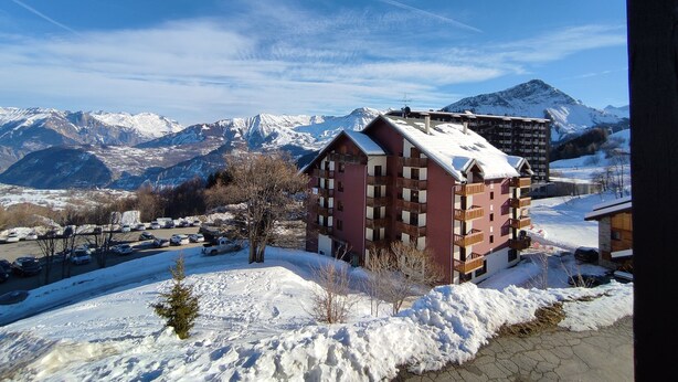 A mountain resort with snow-covered buildings and a view of snow-capped mountains. - Le Corbier - Résidence Les Pistes, Appartement 6/7 Personnes au Pied des Pistes (Villarembert)