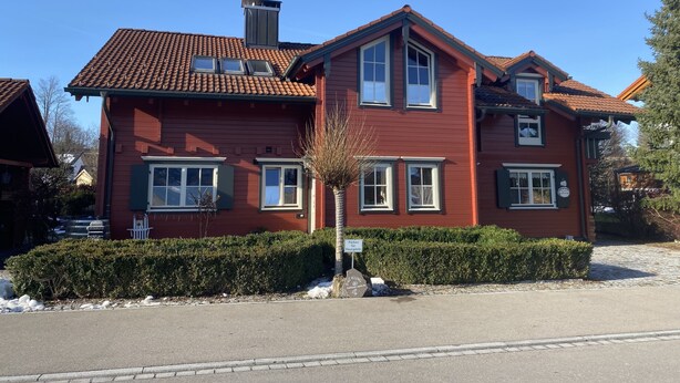 A two-story house with a red exterior, multiple windows, and a chimney. - Rotes Haus Füssen Apartment Romantik (Füssen)