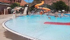 Une piscine avec un toboggan et une vue sur les montagnes en arrière-plan.