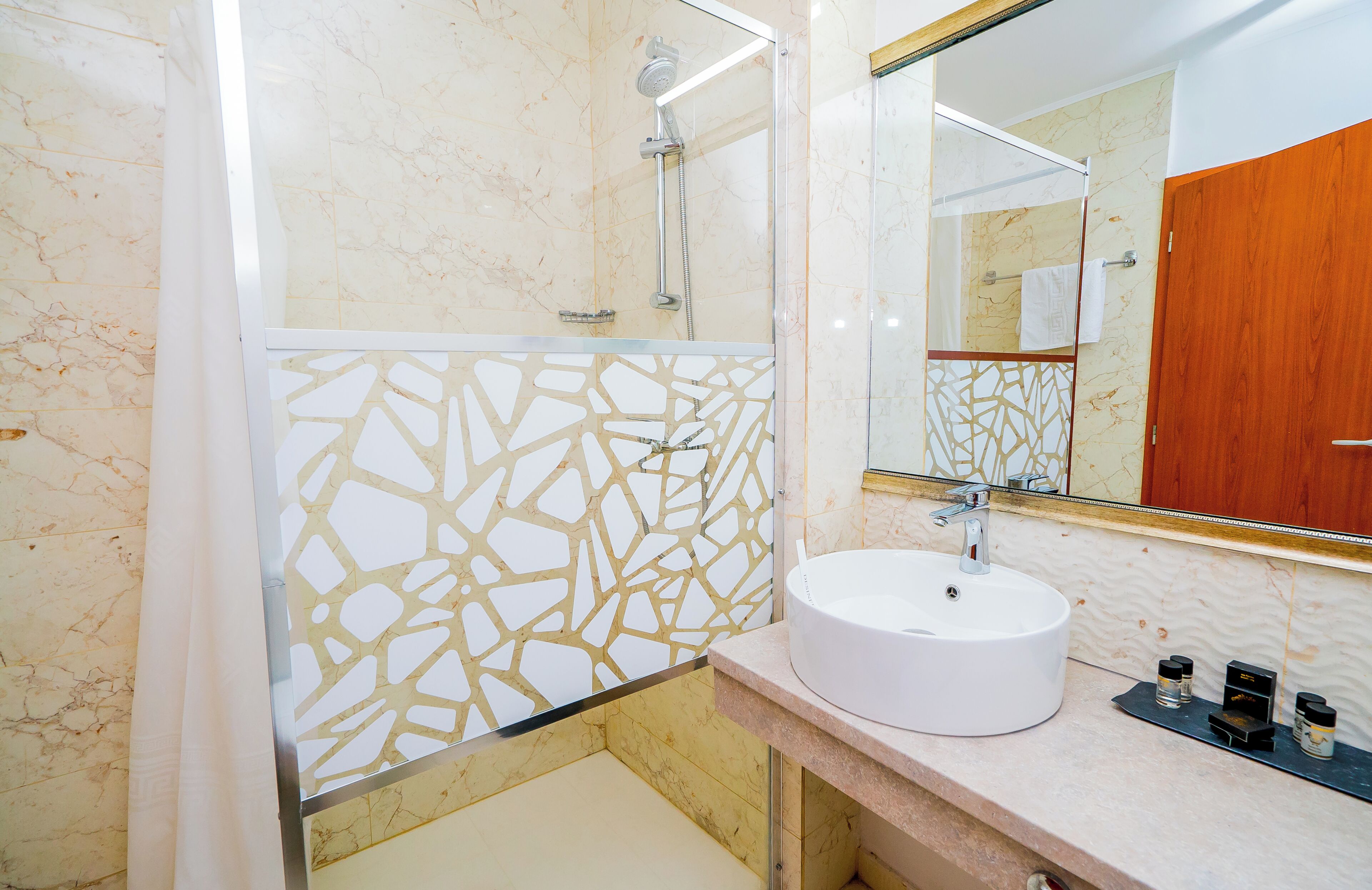 Ein Badezimmer mit Waschbecken, Dusche und Spiegel.