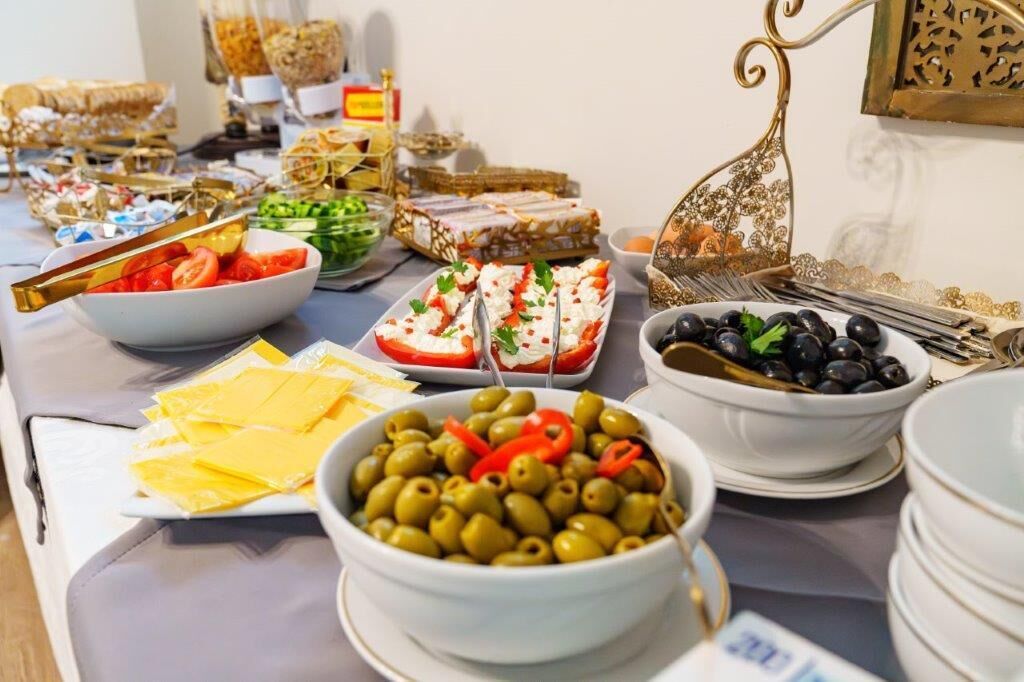 Een buffet met diverse gerechten, zoals olijven, kaas en salades.