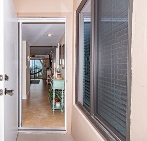 Enter a well-appointed hallway leading to a dining area with a table and chairs.