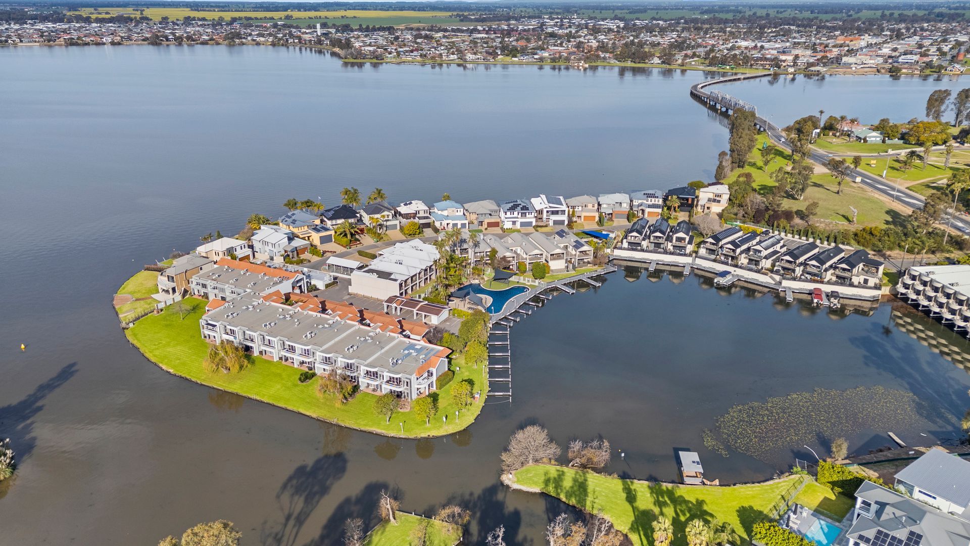 A residential area with houses, a bridge, and a body of water.